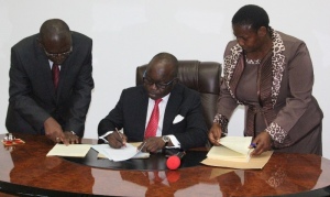 Governor Emmanuel Uduaghan of Delta State (middle) the Athoney General and Commissioner for Justice, Chief Charles Ajuya (left) and the Deputy Clerk of the House, Mrs. Margaret Kanu when the governor signs the Delta State Small and Medium Enterprises Agency Bill into law