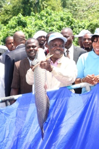 Governor Emmanuel Uduaghan of Delta State displaying fish at Camp 74 Fish Farm in Asaba