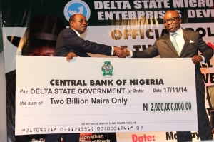 MICRO CREDIT: The Central Bank of Nigeria Governor, Mr. Godwin Emefile (left) presenting a Cheque of 2billion naira CBN Micro, Small and Medium Enterprises Development ( MSMED) fund  to Governor Emmanuel Uduaghan of Delta State (right) during the official rolling out of the CBN MSMED fund held in Asaba